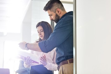 Fototapeta premium Businessman with female colleague reviewing project in office