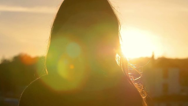 woman looks the sunset: slow motion footage