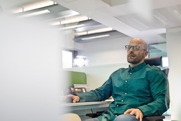 Mid adult businessman sitting on chair in office