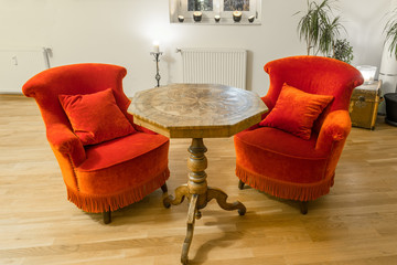 Antiker Beistelltisch mit Intarsien und rote Sessel