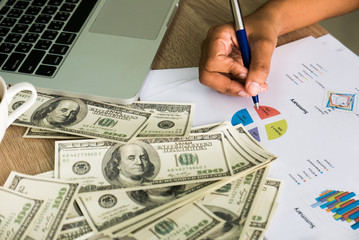 Closeup of Asian female right hand writes something on business charts