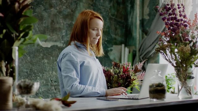 florist typing on laptop
