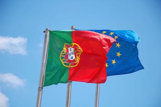 Flags of Portugal and European Union on the sky background