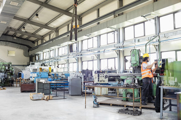 Young manual worker operating machinery in metal industry