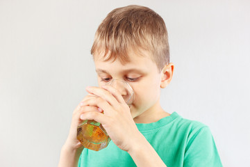 Little cut boy drinking a fresh lemonade