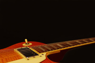 Fototapeta premium Vintage electric guitar closeup on the black background, with plenty of copy space. Selective focus.