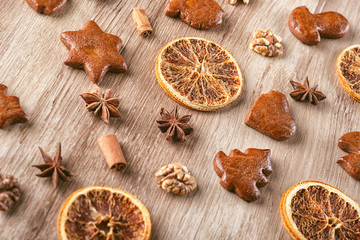 gingerbread with baking ingredients like cinnamon, orange slices and star anise on wooden background, christmas background