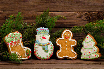Gingerbread: sock, snowman, man, fir-tree, spruce branch on a background of a wooden wall, close up