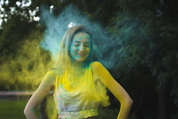Smiling woman with powder Holi exploding around her