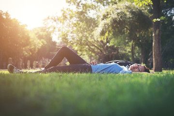 Young hipster woman lying down on grass.