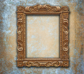 Golden carved antique frame on grunge worn wall