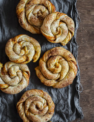 Pumpkin cinnamon puff pastry swirls rolls on a wooden table, top view