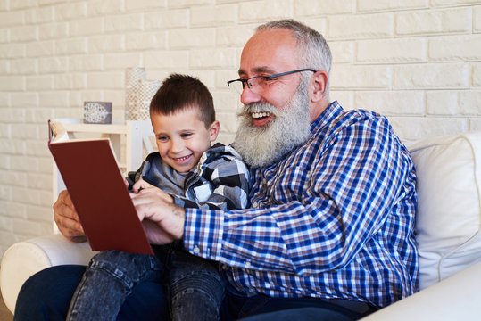 Grandson enjoys reading a book with his granfather