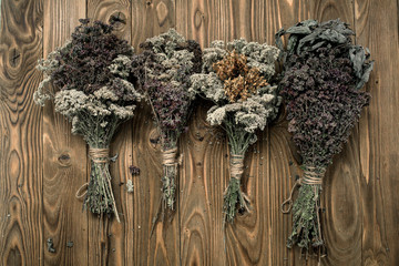 Bunches of dried herbs on wooden background