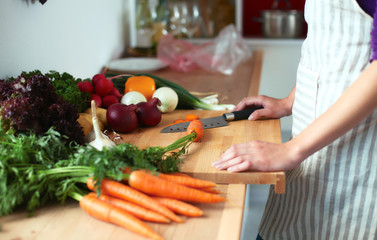 Young woman cutting vegetables in the kitchen
