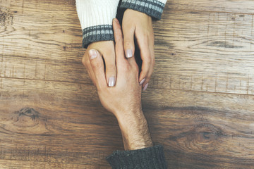 man and a woman holding hands at a wooden table