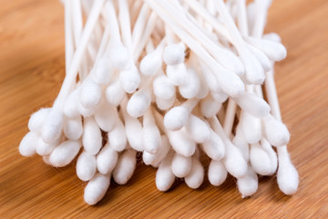 Fototapeta na wymiar Pile of white cotton swabs isolated on wood background