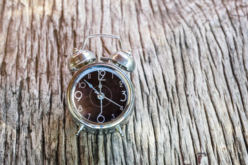 clock placed on wooden background in retro tone