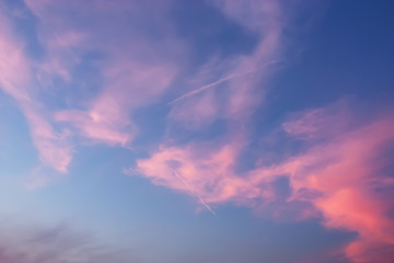 Beautiful dramatic Twilight sky and clouds with long line of jet engine clouds.