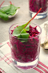 Fresh beet salad with chard leaves in glasses on linen gray background