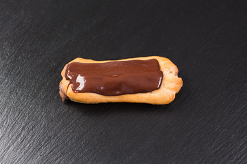 Chocolate eclair on black background. Eclairs with glaze.