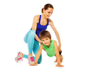Fototapeta na wymiar Sporty mother teaching her son doing pushing ups