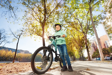 Obraz premium Happy boy in helmet holding bike