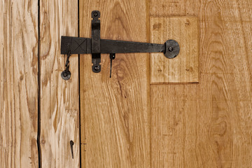Rustic wooden door with hammered old fashioned iron lock