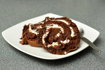 Chocolate swiss roll displayed on a white plate