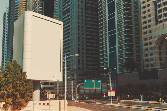 Mock Up Of Blank Vertical White Advertising Billboard In Dubai With Residential And Office Modern Contemporary Skyscrapers And Empty Highway Behind