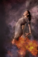 beautiful woman dancind in fire and clouds at dark
