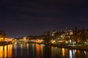 Fototapeta na wymiar Bridge by the Seine river with view on the Hotel de ville in Paris at night