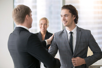 Two smiling businessmen handshaking