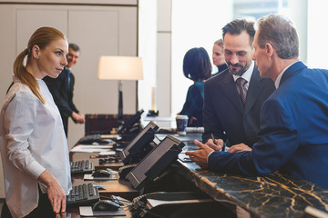 Attractive woman registering on arrival in hotel