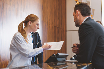 Friendly hotel worker at reception desk