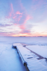 Frozen lake and fishing dock at sunrise