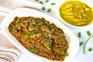 Bengali Fish Curry with some caramelized onion and spring onion sprinkled on it.