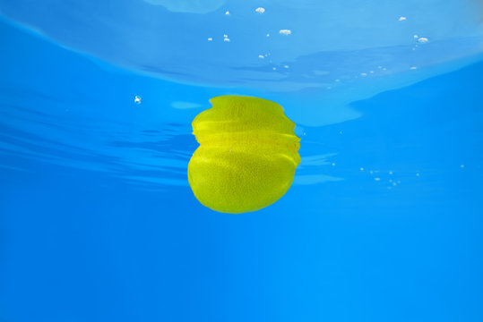 Lemon splashing in water on blue background