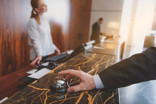 Man using hotel bell at reception