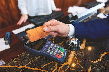 Male customer using debit machine in hotel