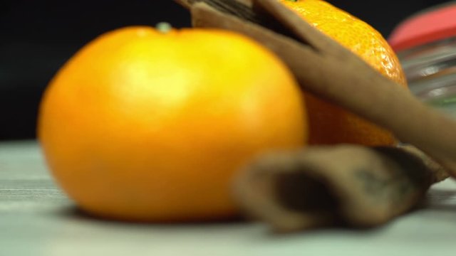 Mandarin oranges - tangerines and cinnamon sticks, macro shot, dark background, focus point moved from front to back