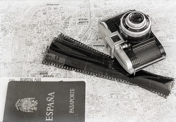 Overheat of old camera, negatives and passport on map background. Subjects captured against soft window lighting.