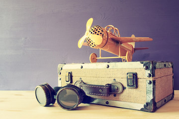 vintage toy plane and old suitcase next to pilot glasses