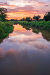 Obraz na płótnie Canvas sunrise reflection in a canal