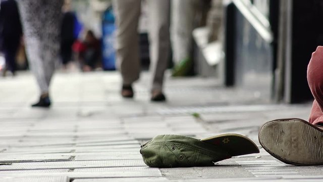 Man gives coin to beggar on the street