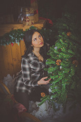 beautiful girl in plaid shirt near the Christmas tree.