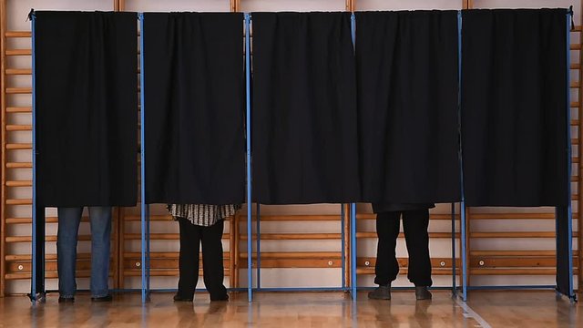Unrecognizable people casting votes into the ballot box during elections