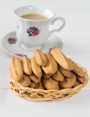 Gingerbread cookies with a cup of coffee on a white wooden table.