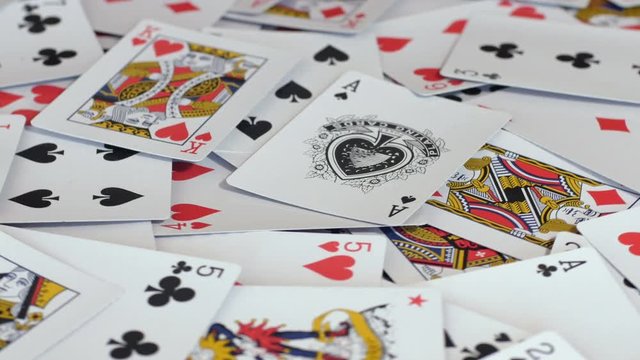 Heap of various poker cards,hearts, diamonds, spades and clubs gambling, card games in casino. Close up, rotating, seamless loop, 4K Ultra HD.