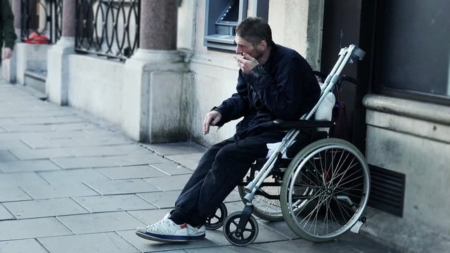 poor man on the wheelchair waiting for charity